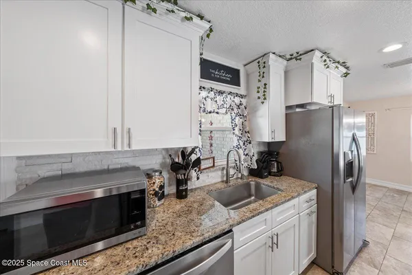 a kitchen with stainless steel appliances granite countertop a refrigerator and a sink