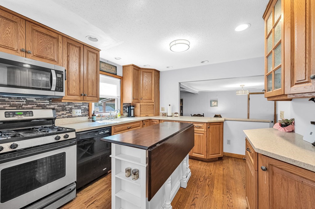 163 Cedar Road Longmeadow, MA 01106 - Photo 9 of 39 a kitchen with stainless steel appliances a stove sink microwave and cabinets