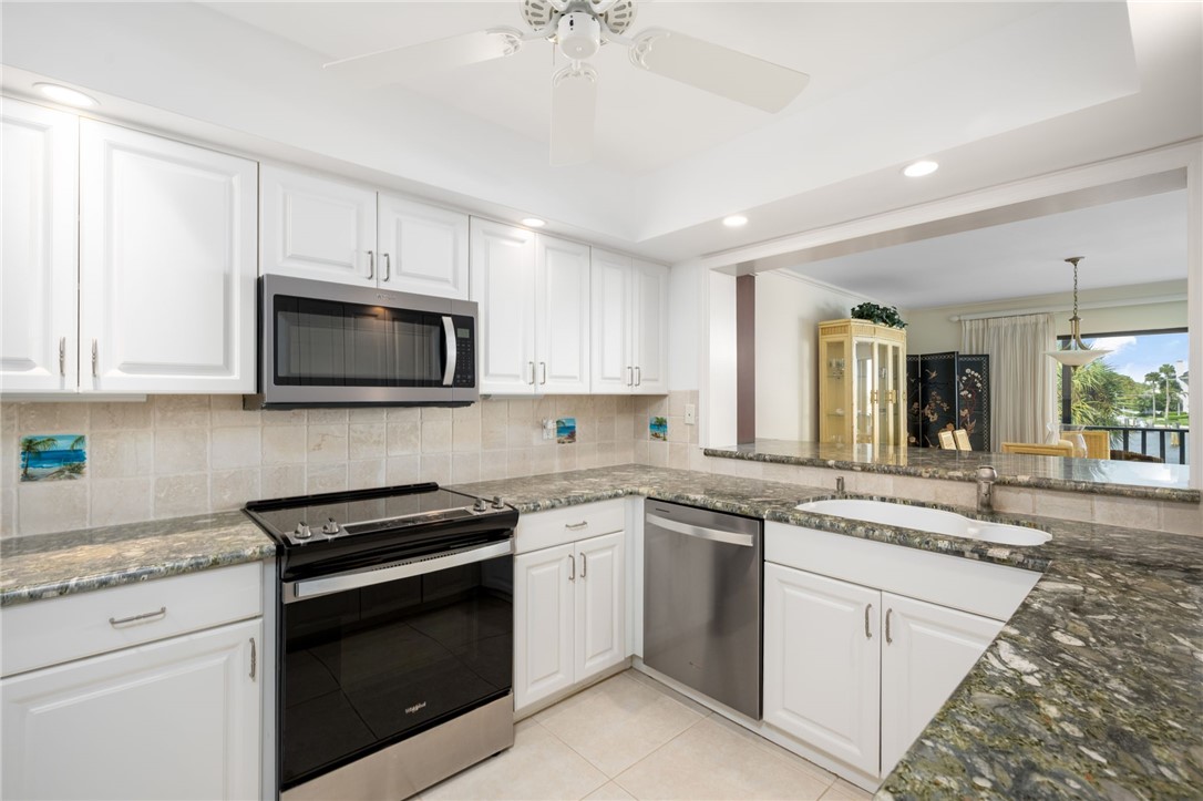 1875 Bay Road, Unit 215H Vero Beach, FL 32963 - Photo 12 of 36 a kitchen with a sink stove and microwave