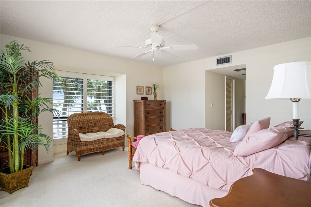1875 Bay Road, Unit 215H Vero Beach, FL 32963 - Photo 15 of 36 a bedroom with a bed a couch and a potted plant