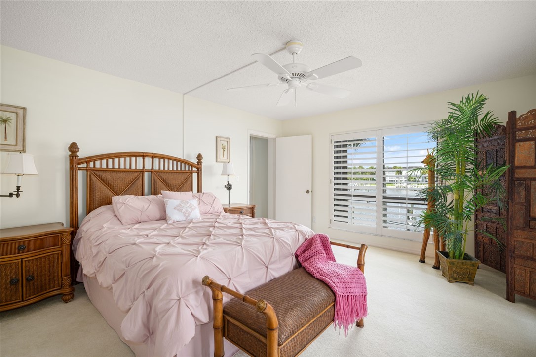 1875 Bay Road, Unit 215H Vero Beach, FL 32963 - Photo 16 of 36 a bedroom with a large bed and a tv
