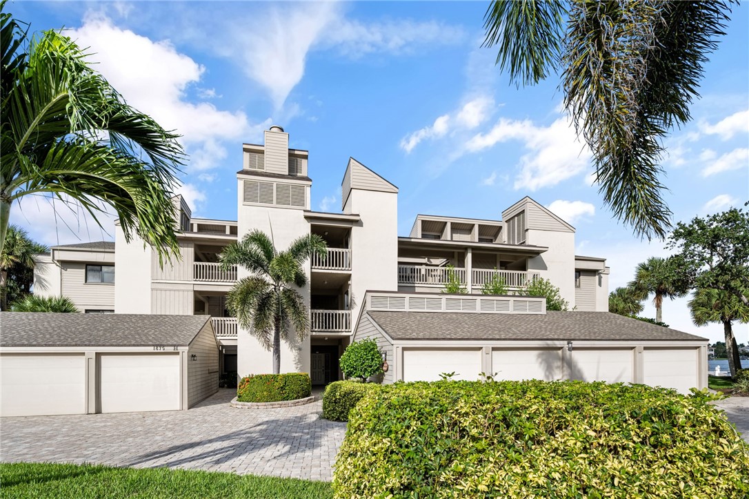 1875 Bay Road, Unit 215H Vero Beach, FL 32963 - Photo 2 of 36 a front view of a house with a yard and garage