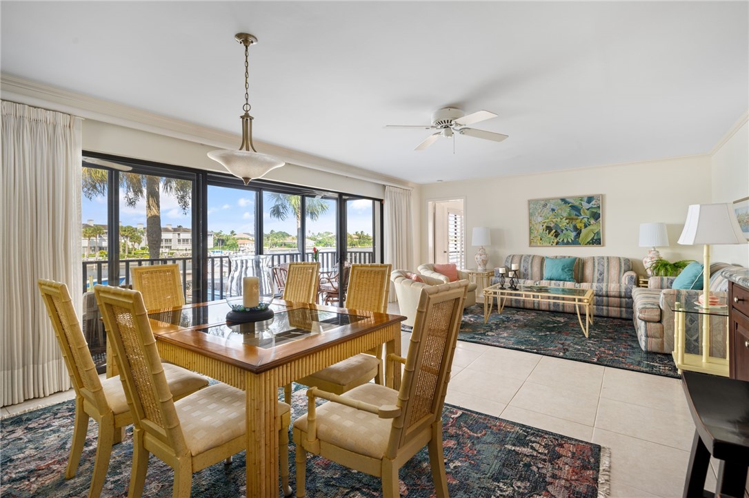 1875 Bay Road, Unit 215H Vero Beach, FL 32963 - Photo 7 of 36 a dining room with furniture a chandelier and wooden floor