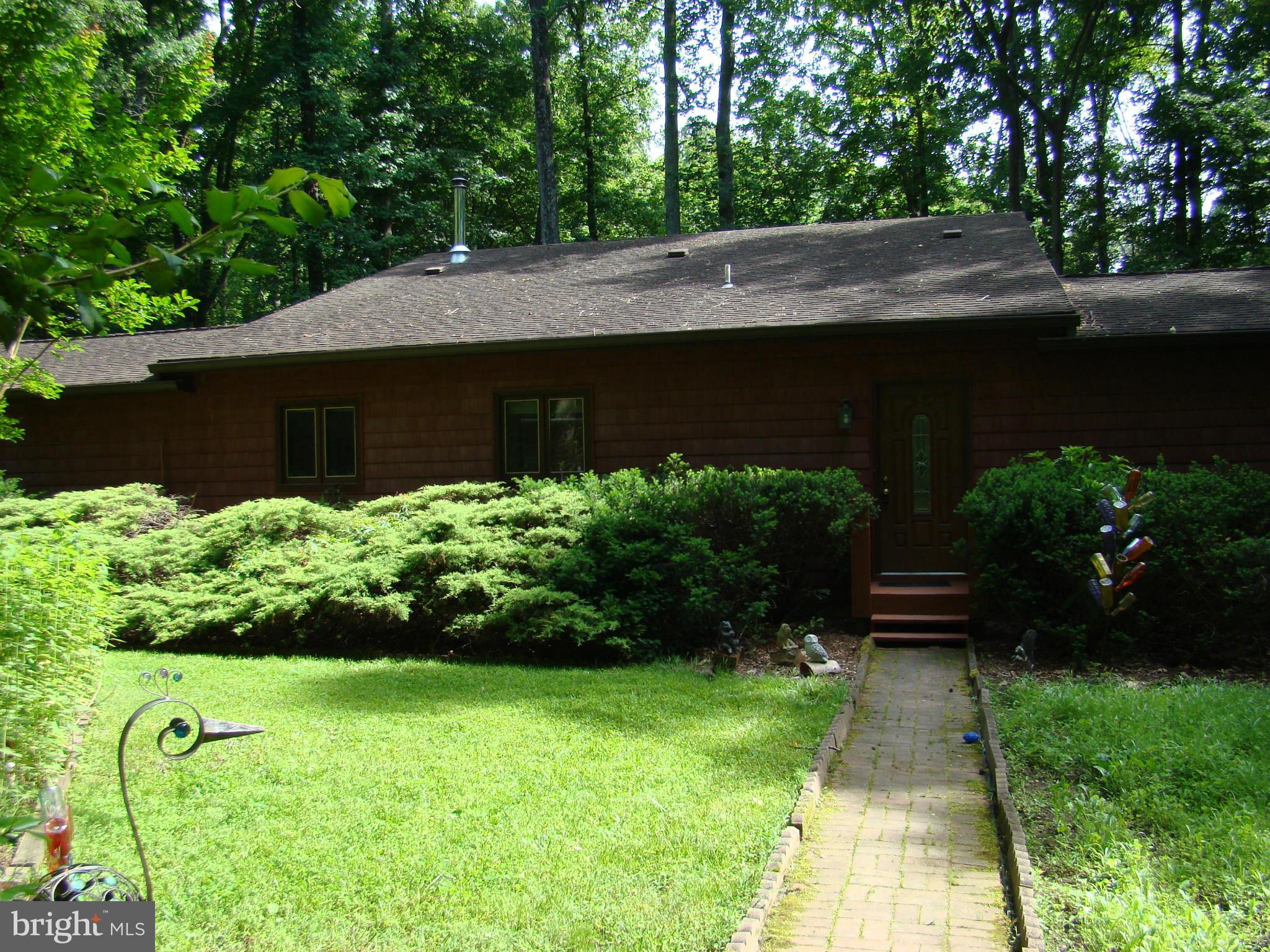 3100 Ross Road St. Leonard, MD 20685 - Photo 2 of 23 a backyard of a house with plants and large trees