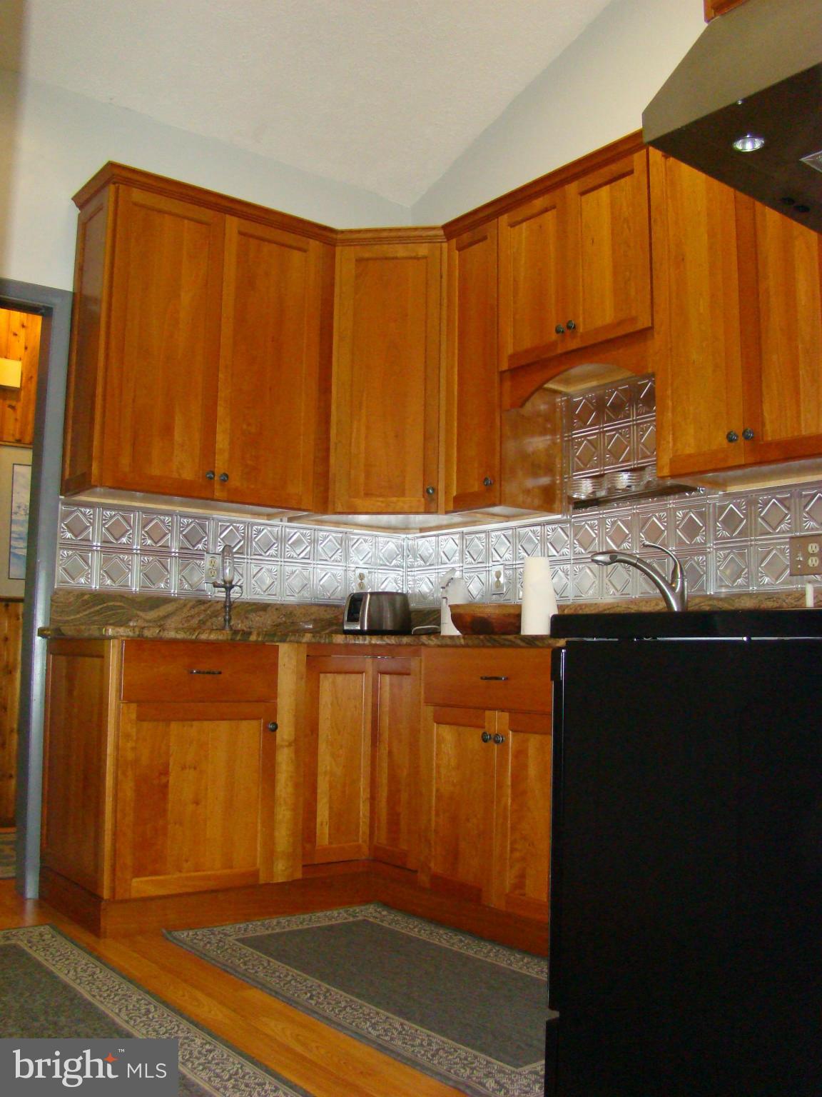 3100 Ross Road St. Leonard, MD 20685 - Photo 4 of 23 a kitchen with granite countertop cabinets and black appliances