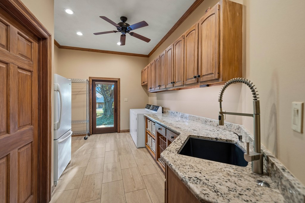 2409 West Commerce Street San Saba, TX 76877 - Photo 19 of 96 a kitchen with stainless steel appliances granite countertop a refrigerator a stove and a sink with wooden floor