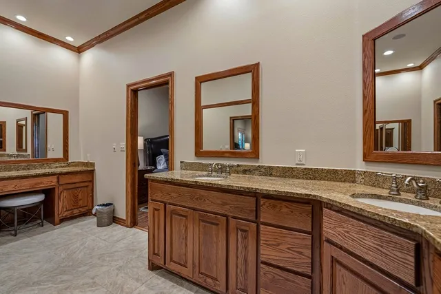 a bathroom with a double vanity sink a toilet and shower