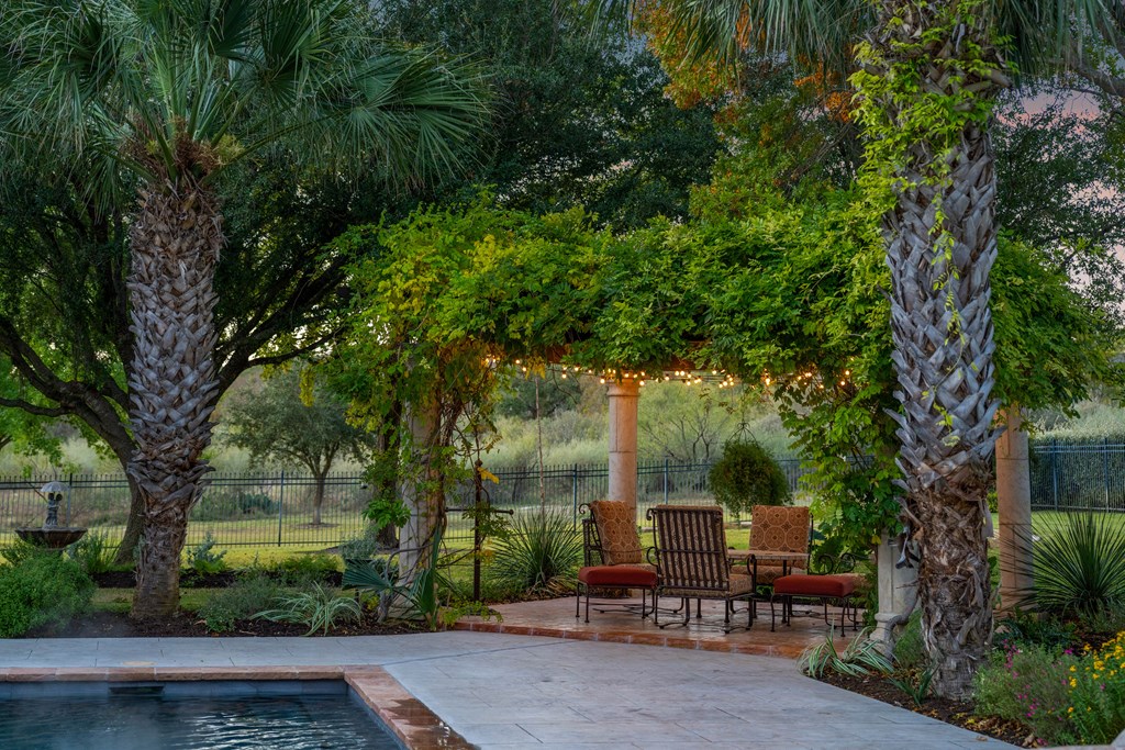 2409 West Commerce Street San Saba, TX 76877 - Photo 47 of 96 a view of a patio with table and chairs potted plants and large tree
