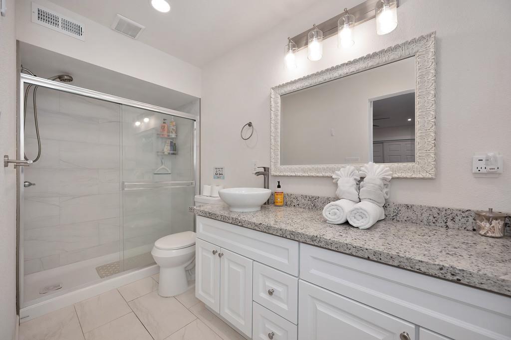 3191 Fort Jim Road Placerville, CA 95667 - Photo 13 of 30 a bathroom with a granite countertop sink a toilet and a mirror