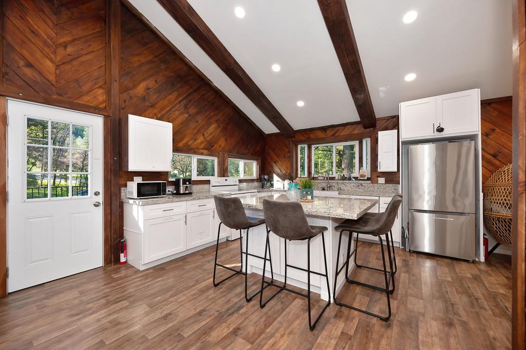3191 Fort Jim Road Placerville, CA 95667 - Photo 18 of 30 a kitchen with stainless steel appliances a dining table chairs refrigerator and wooden floor