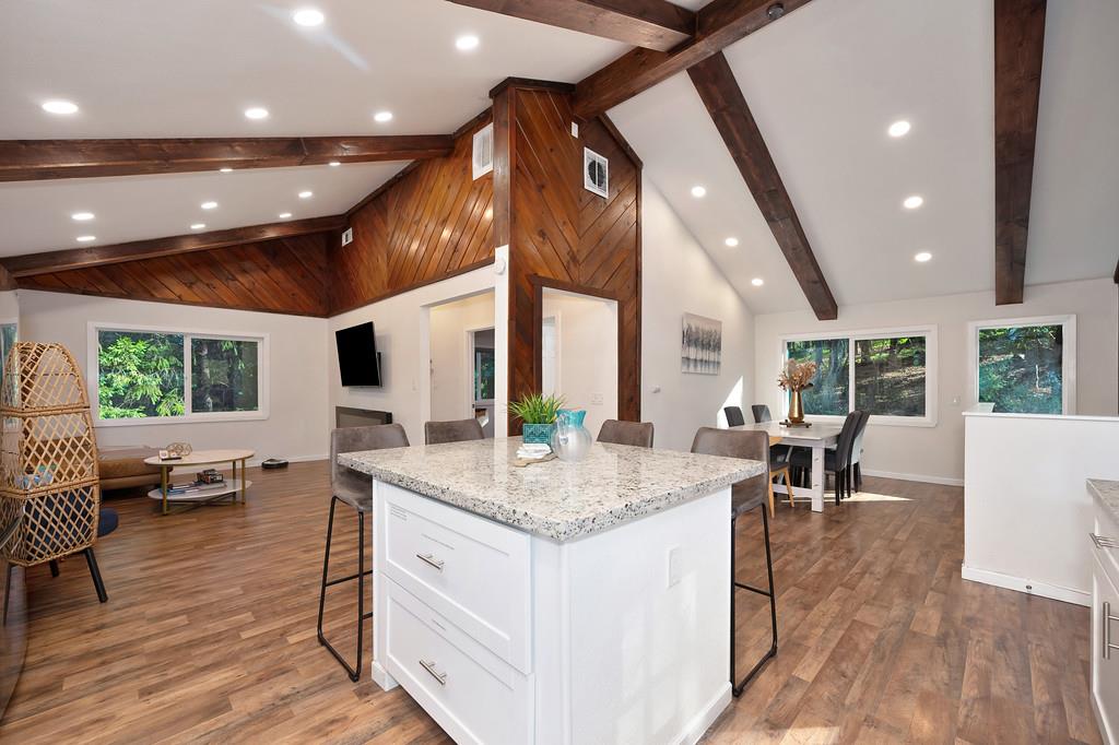 3191 Fort Jim Road Placerville, CA 95667 - Photo 19 of 30 a open kitchen with stainless steel appliances granite countertop kitchen island a stove a dining table and chairs with wooden floor