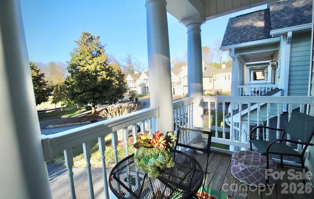 a balcony with wooden floor table and chairs