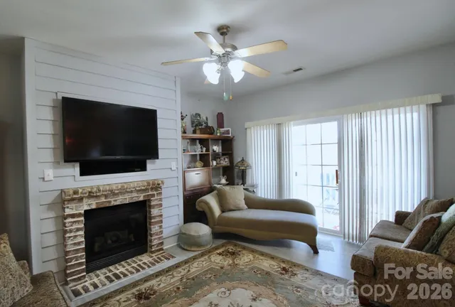 a living room with furniture a flat screen tv and a fireplace