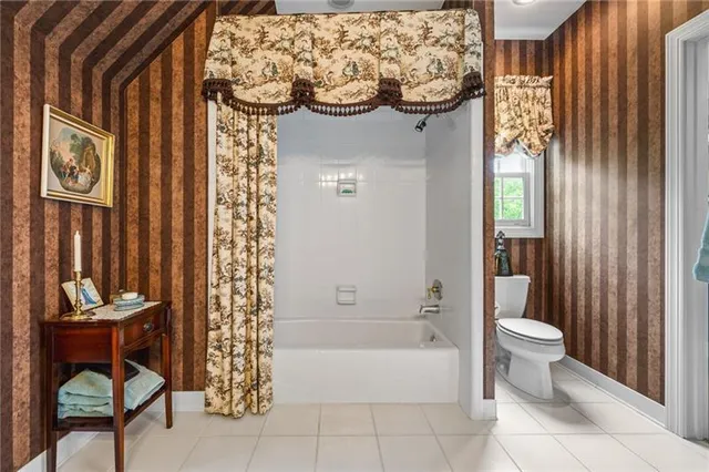 a bathroom with a toilet sink vanity and mirror