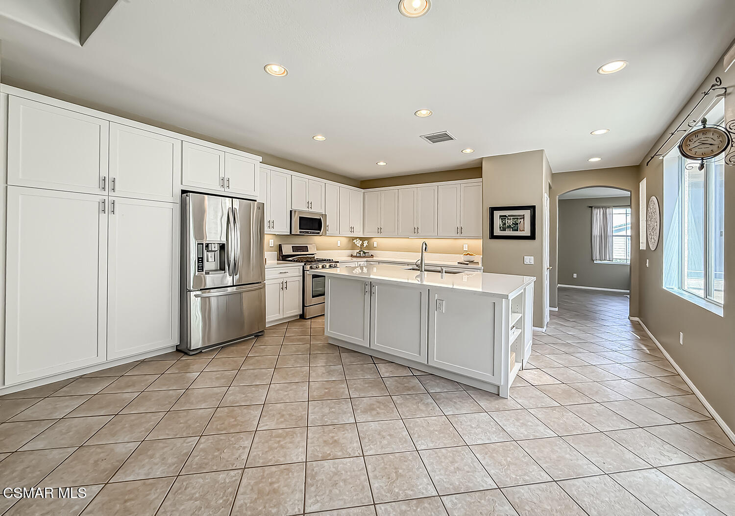 2511 Aurora Lane Simi Valley, CA 93063 - Photo 4 of 48 a kitchen with white cabinets a refrigerator and a stove top oven