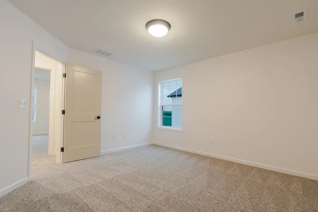 an empty room with a window and wooden floor