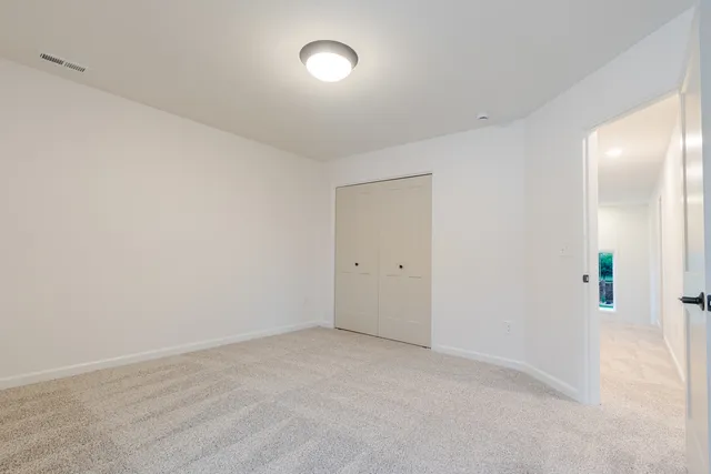 an empty room with a window and wooden floor
