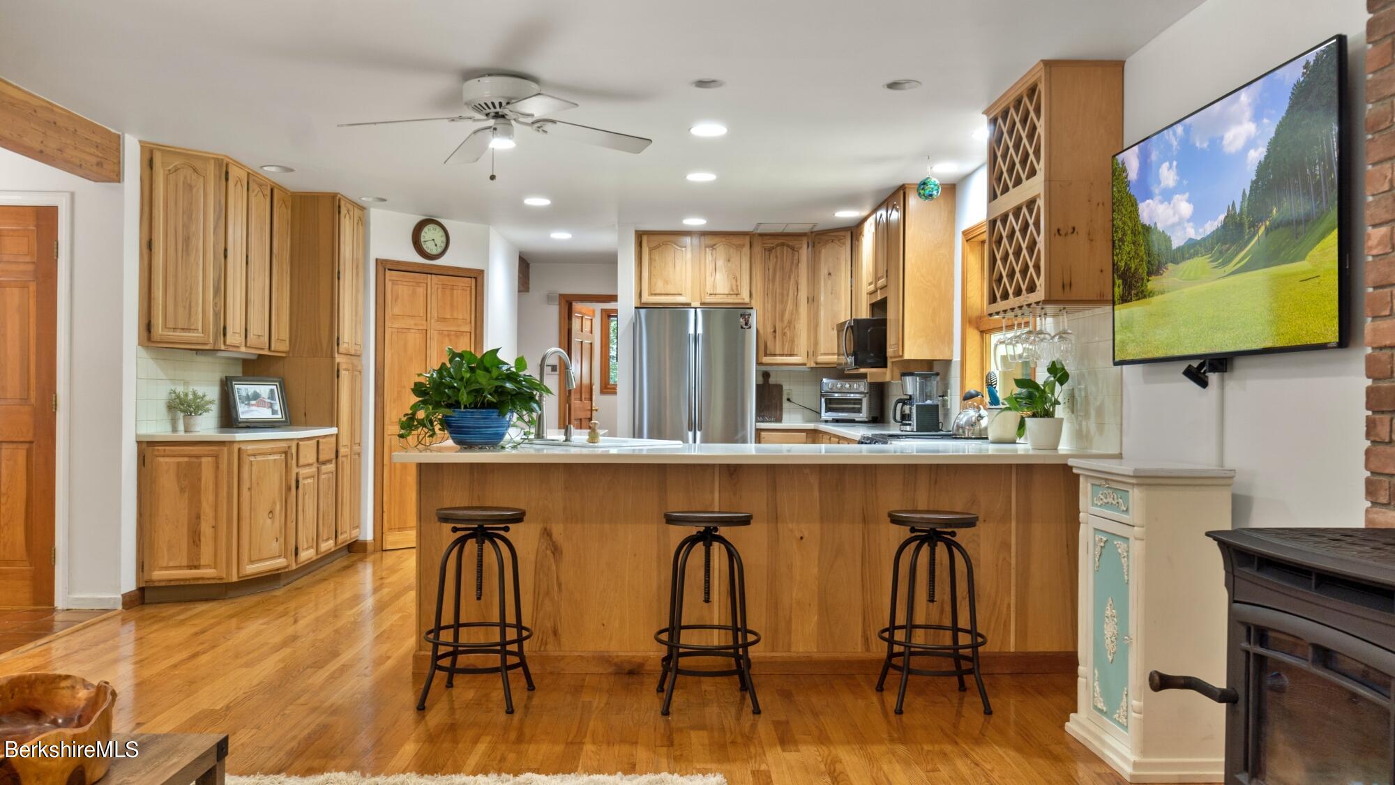499 Norton Road Otis, MA 01029 - Photo 7 of 31 a kitchen with stainless steel appliances granite countertop a stove a refrigerator a kitchen island with a dining table and chairs