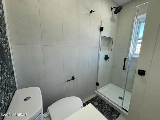 a bathroom with a toilet and a shower