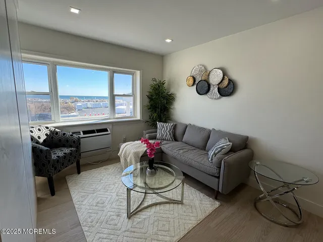 a living room with furniture a rug and a floor to ceiling window