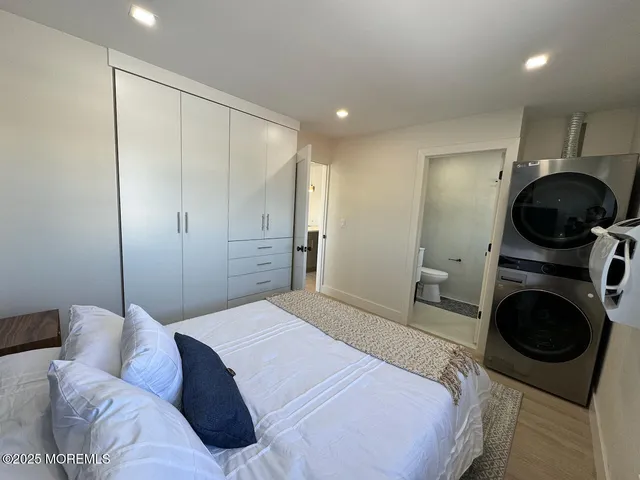 a bedroom with a bed a mirror and a bathtub