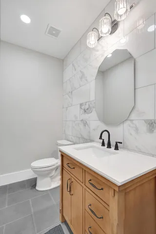 a bathroom with a sink a toilet and mirror