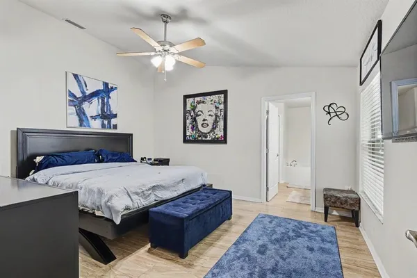 a bedroom with a large bed and a chandelier