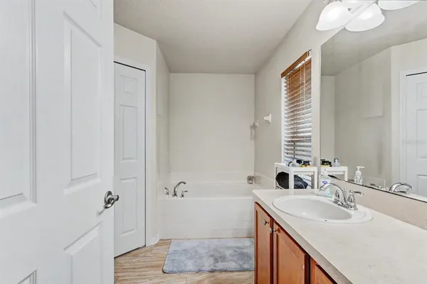 a bathroom with a sink double vanity granite tub shower and a mirror