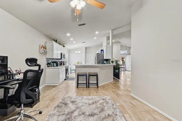 a living room with stainless steel appliances kitchen island granite countertop furniture and a view of kitchen