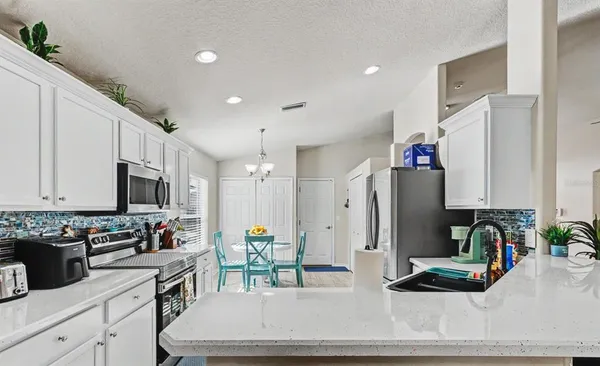 a kitchen with stainless steel appliances granite countertop a refrigerator and a stove top oven