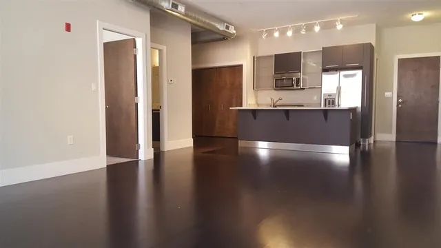 a view of kitchen with stainless steel appliances a refrigerator and wooden floor