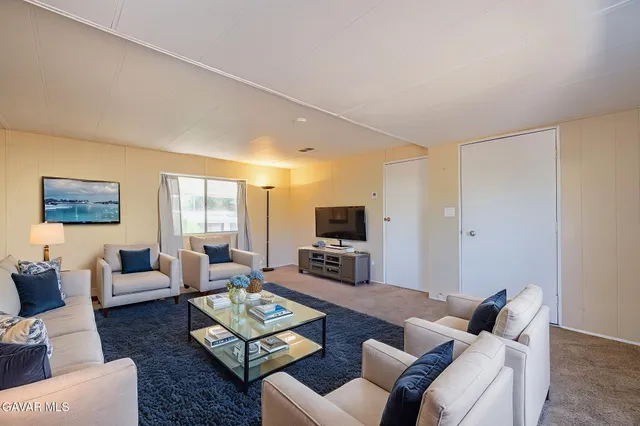 a living room with furniture couches and a flat screen tv
