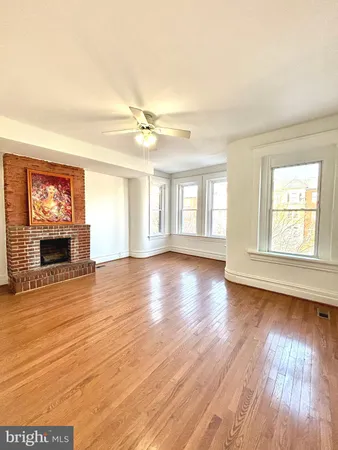 a view of a livingroom with wooden floor and a fireplace