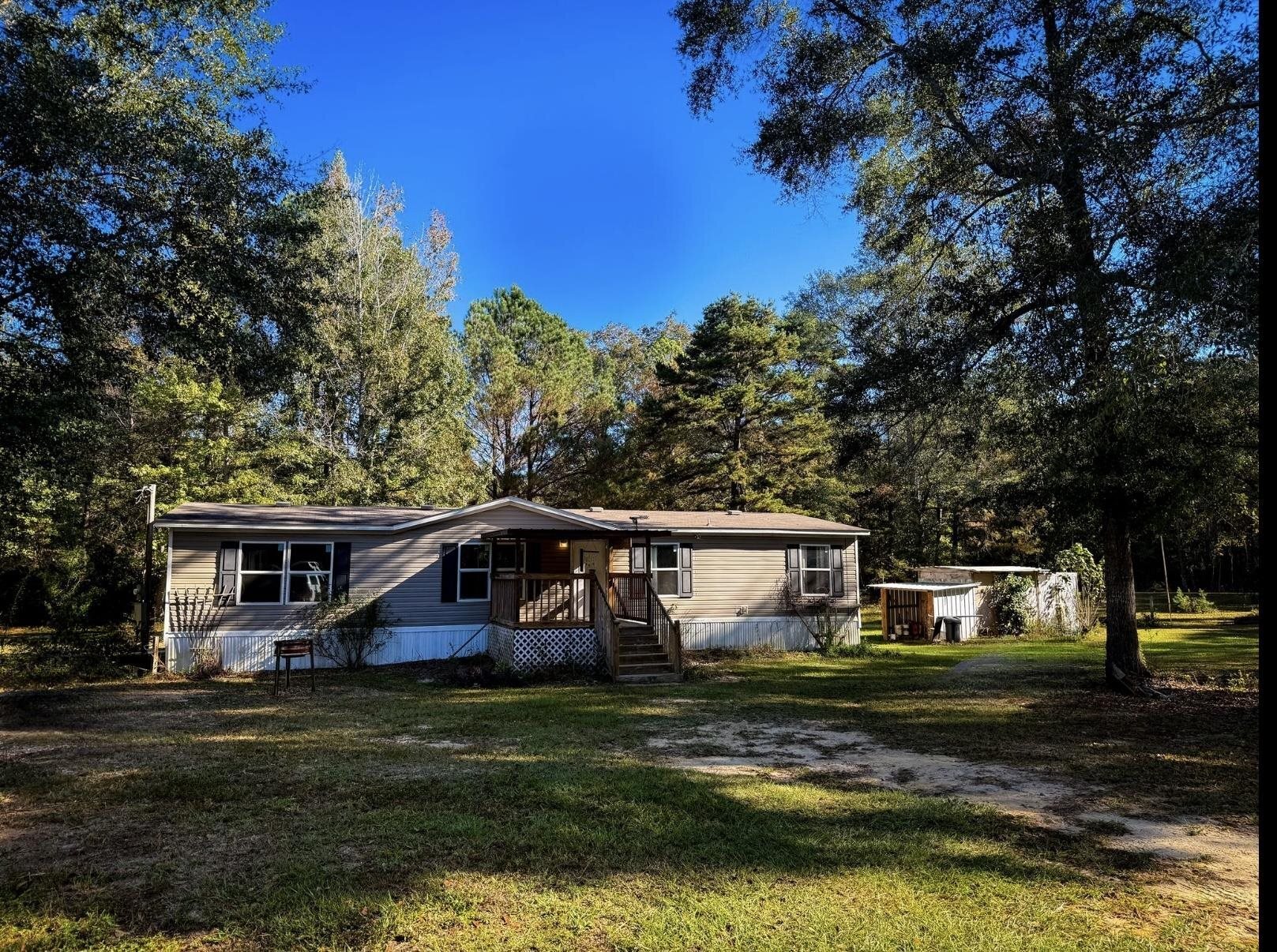 Manufactured / mobile home featuring a front yard and a wooden deck