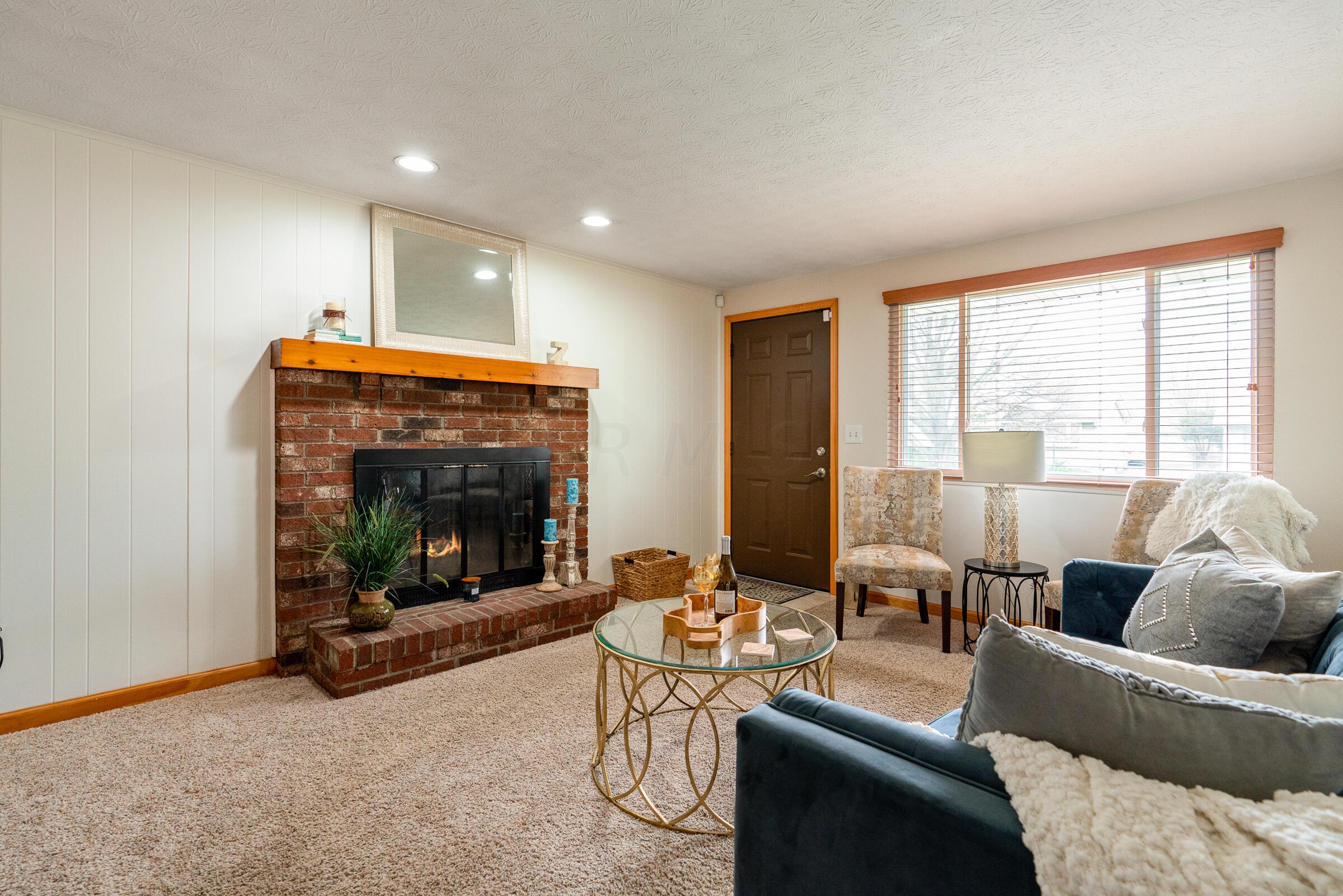 1839 Brookfield Road Columbus, OH 43229 - Photo 3 of 32 Light filled living room with a wood-burning brick fireplace.