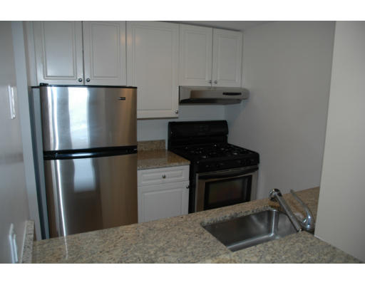 42 8th Street, Unit 5526 Boston, MA 02129 - Photo 4 of 13 a kitchen with stainless steel appliances granite countertop a refrigerator a stove and a sink