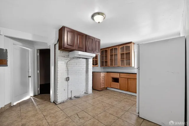 a view of kitchen with refrigerator cabinets and window