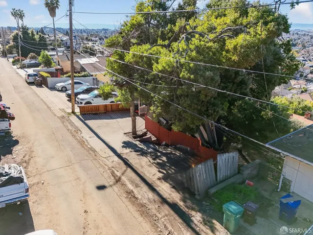 an aerial view of residential houses with outdoor space and trees