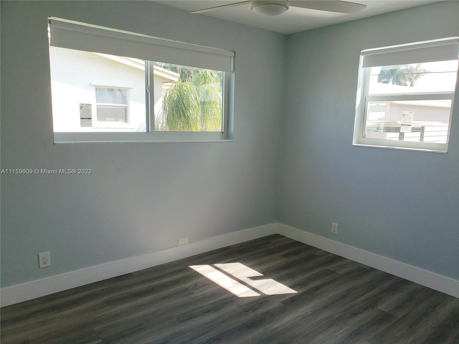 326 Southeast 3rd Terrace Dania Beach, FL 33004 - Photo 15 of 29 an empty room with wooden floor and windows