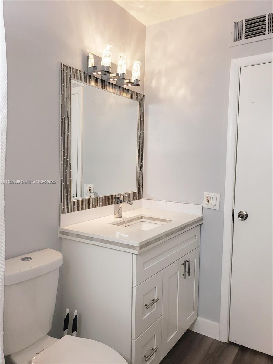 326 Southeast 3rd Terrace Dania Beach, FL 33004 - Photo 18 of 29 a bathroom with a granite countertop sink a toilet and a mirror