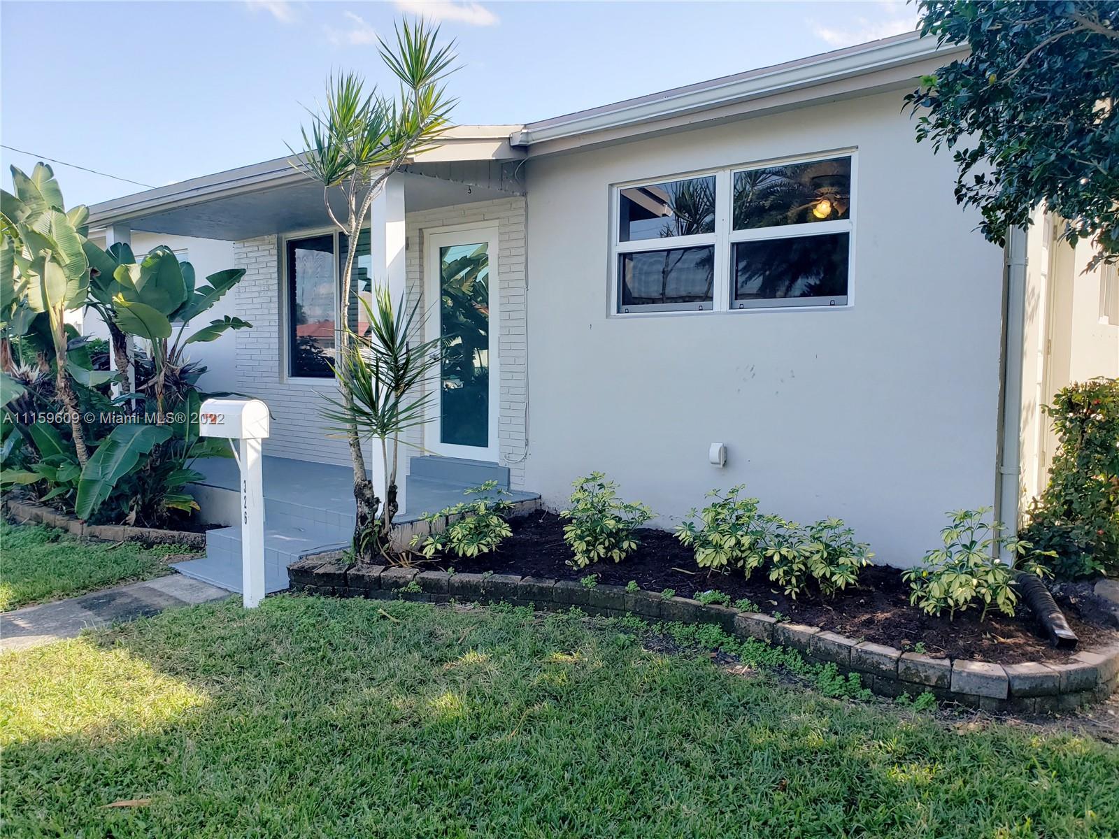 326 Southeast 3rd Terrace Dania Beach, FL 33004 - Photo 23 of 29 a front view of house with yard and outdoor seating
