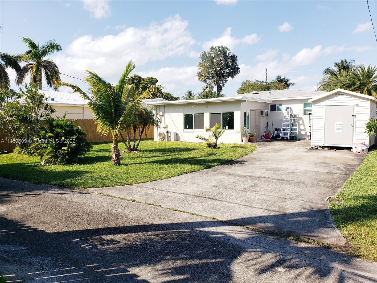 326 Southeast 3rd Terrace Dania Beach, FL 33004 - Photo 28 of 29 a front view of a house with a yard and potted plants