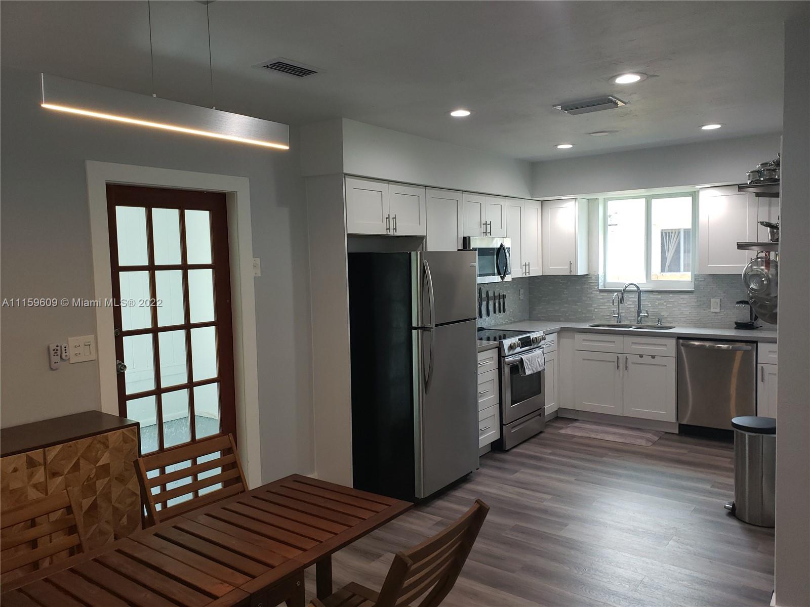 326 Southeast 3rd Terrace Dania Beach, FL 33004 - Photo 5 of 29 a kitchen with refrigerator cabinets and wooden floor