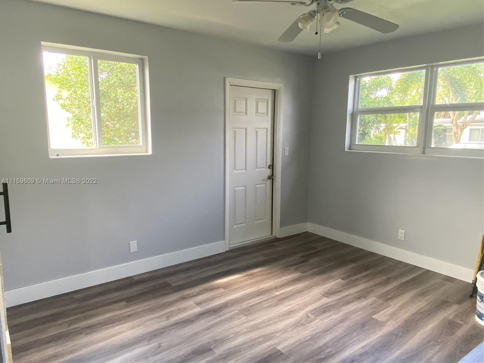 326 Southeast 3rd Terrace Dania Beach, FL 33004 - Photo 9 of 29 a view of an empty room with wooden floor and a window