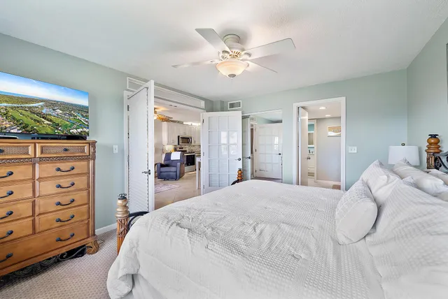 a spacious bedroom with a bed and a mirror