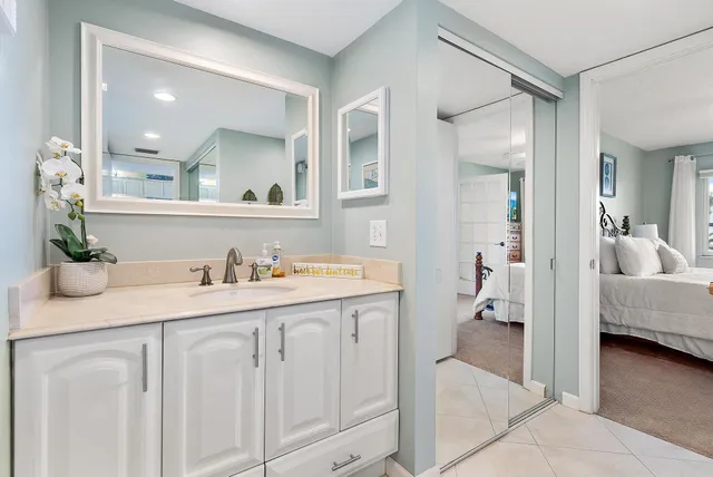 a en suite bathroom with a granite countertop sink and mirror