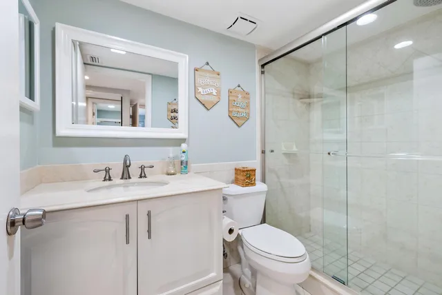 a bathroom with a granite countertop toilet sink and a mirror