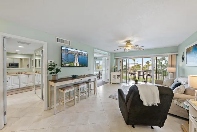 a living room with furniture a large window and a flat screen tv