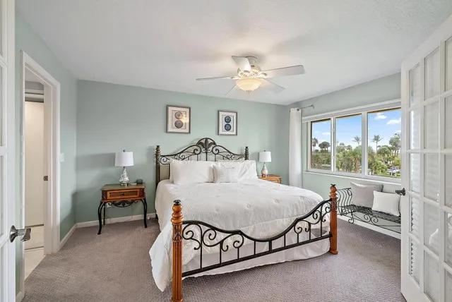 a bedroom with a large bed and a chandelier