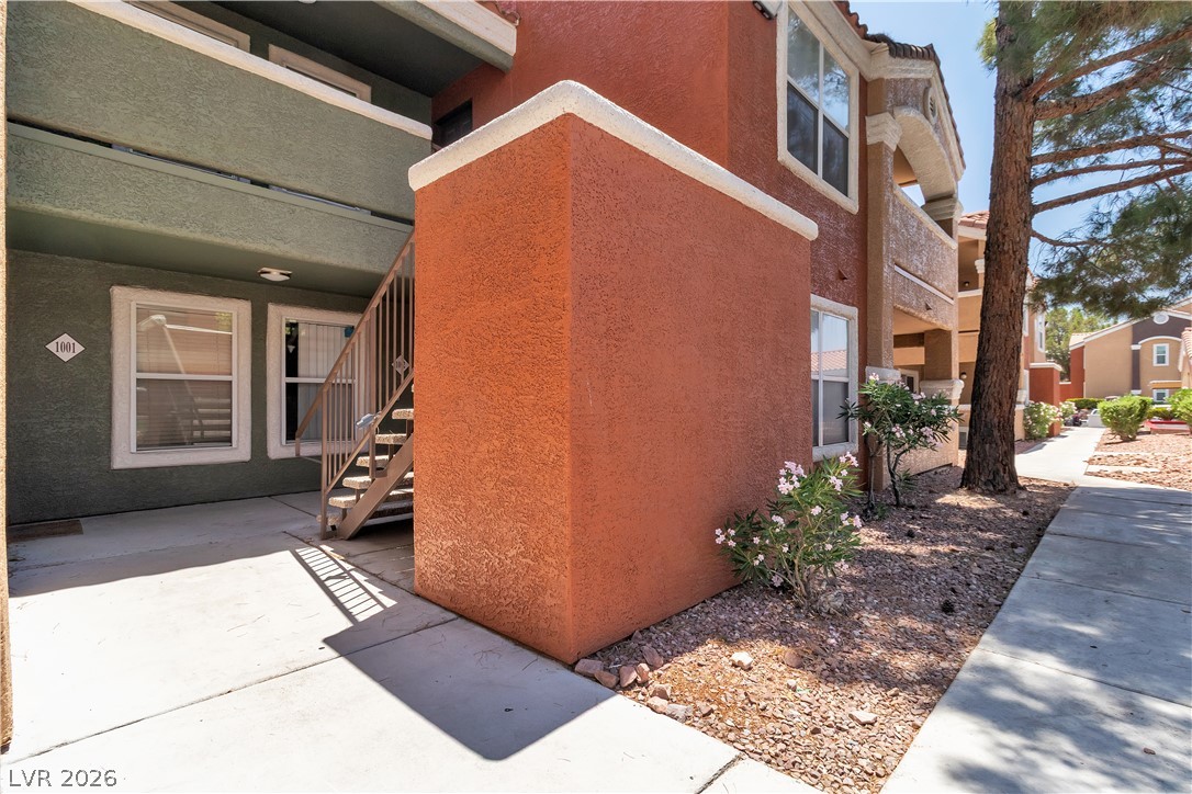 8101 West Flamingo Road, Unit 2001 Las Vegas, NV 89147 - Photo 3 of 28 A classic stucco facade with a contemporary touch, featuring inviting walkways and natural landscaping.